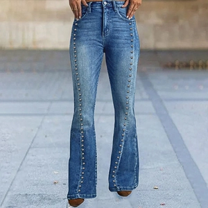 Detail of high waisted flare jeans with silver metal rivets on the blue denim front