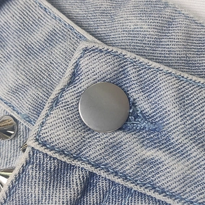 Pantaloncini in denim azzurro con bottoni in metallo argento e dettagli di rivetti