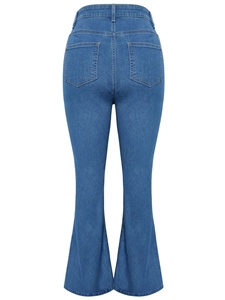 Detail of high waist flare jeans showing back pockets and medium wash denim fabric