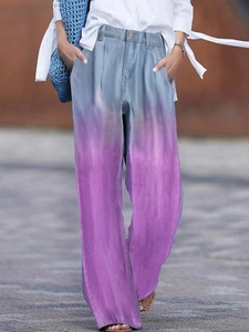 Détail d'un jean taille haute à jambes larges avec dégradé bleu-violet et bouton en métal