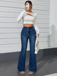 Detailed close-up of high-waisted flared jeans featuring raw hem and vintage blue wash