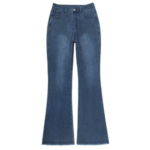 Close-up of vintage blue flared jeans showing washed texture and frayed hem detail