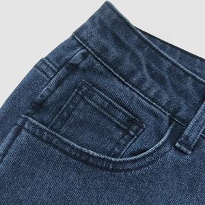 Detail of high waist denim jeans with double front pockets and reinforced stitching