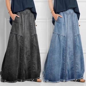 Detail view of A-line denim maxi skirts with vertical seams and frayed hem design