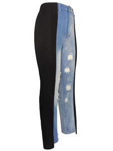 High-waisted patchwork jeans with black and blue denim panels and distressed detailing