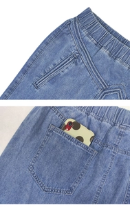 Close-up of elastic high waist and back pocket detail on blue denim A-line midi skirt