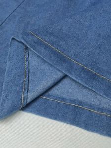 Close-up of blue denim skirt fabric featuring durable yellow double contrast stitching detail