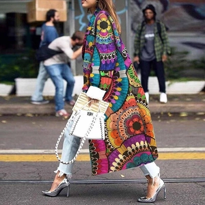 Detail van de meerkleurige boho-print op een lange trenchcoat met dubbele rij knopen