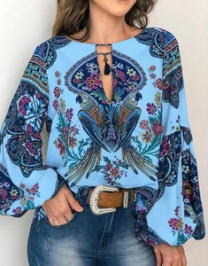 Détail d'une chemise bohème à imprimé perroquet et fleurs avec liens à glands