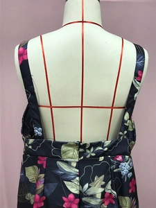 Detail of floral print jumpsuit featuring low back design and zipper closure