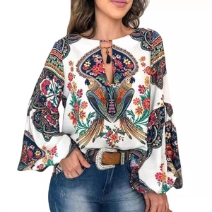 Détail de la blouse bohème à imprimé perroquet avec col en goutte et pompons