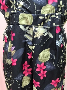 Detailed view of floral print fabric with pink flowers and smocked waist design