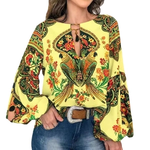 Détail de chemisier bohème jaune avec imprimé perroquet, liens à glands et manches lanternes