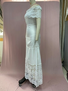 Detailed view of white off-the-shoulder lace dress with intricate tiered hollow patchwork