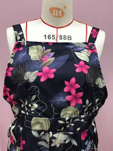 Close-up of tropical floral print on dark fabric with button adjustable strap detail