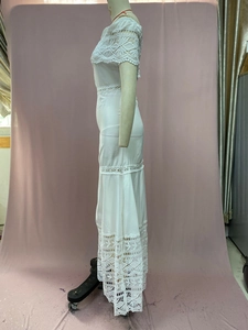 Detailed close-up of white lace stitching and off-shoulder design on bohemian maxi dress