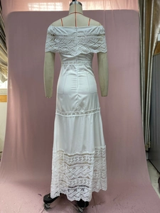 Detail of white off-shoulder lace maxi dress featuring intricate hollow-out crochet patterns