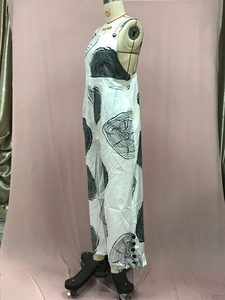 Close-up of white wide-leg jumpsuit with abstract black wood grain print and side buttons