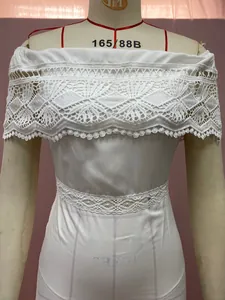 Detailed view of white off-the-shoulder dress with intricate lace stitching and satin finish