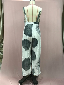 Detail of white wide-leg jumpsuit with black wood grain print and backless halter strap