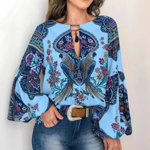 Chemisier bleu ciel à manches lanternes avec imprimé floral perroquet et pompons au col