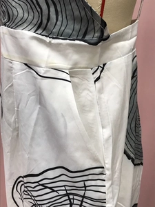 Close-up of wide waistband with pleats and side pocket on black white print pants