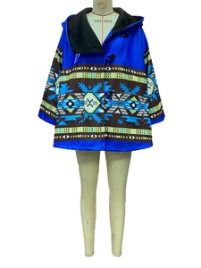 Détail d'un manteau à capuche bleu roi avec imprimés géométriques et boutons duffle-coat