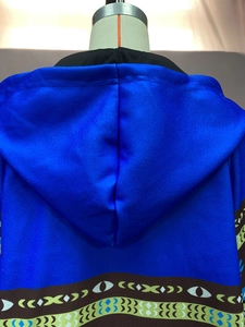 Vue détaillée du manteau à capuche bleu roi avec motif ethnique sur l'ourlet inférieur
