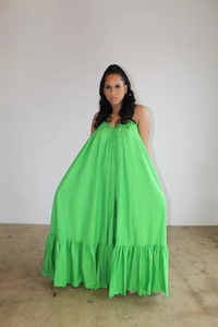 Detail of vivid green oversized maxi dress featuring pleated neckline and wide ruffle hem