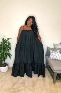 Detail of plus size black summer dress featuring pleated neckline and ruffle hem finish