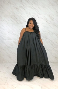 Detail of black maxi tent dress featuring delicate spaghetti straps and ruffled hemline