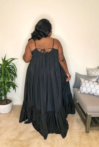 Rear view of black plus size maxi dress with cross-back tie details and ruffled hemline