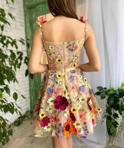 Détail de la broderie florale 3D multicolore et fermeture éclair sur robe champagne
