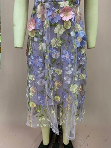 Détails de broderies florales 3D et superposition de mesh sur cette robe violette