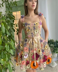 Détails de broderie florale 3D colorée sur robe de fête en tulle avec noeud en ruban