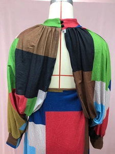 Detail view of back cutout with button closure on geometric patchwork maxi dress