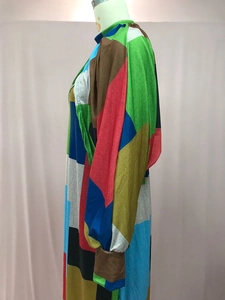 Detailed side view of a colorful geometric patchwork long sleeve dress on a mannequin