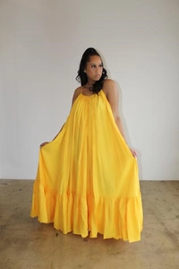 Close-up of bright yellow swing dress showing the ruffled hem and flowing summer fabric