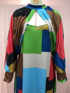 Detail of geometric color-block dress with cut-out neckline and long sleeves