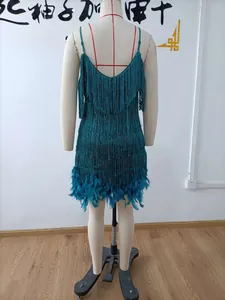 Detail of emerald green fringe dress featuring sparkling sequins and luxury feather trim hem