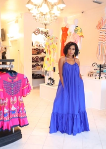 Detail of royal blue halter maxi dress showing glossy satin fabric and ruffle hem