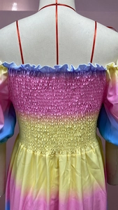 Detailansicht der Smok-Technik und des Verlaufsdrucks auf dem schulterfreien Kleid