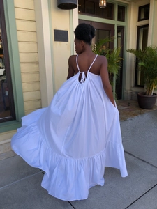 Detail of white backless maxi dress featuring tiered ruffles and delicate spaghetti straps