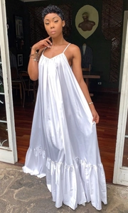 Detail of white satin maxi dress featuring elegant ruffle hem and glossy fabric texture