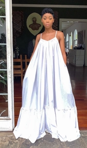 Detail view of white oversized slip dress with ruffled hem and flowing satin texture