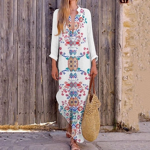Detail of bohemian white cotton maxi dress with vibrant floral print and V-neckline