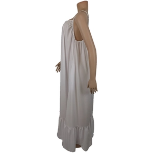 Detail view of white sleeveless summer dress featuring delicate pleats and ruffled hemline