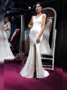 Elegante abito da sera a sirena in pizzo bianco con scollo a V, piume e spacco laterale alto