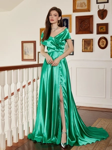 Détail d'une robe de soirée en satin vert émeraude avec décolleté en V et fente haute sur la jambe