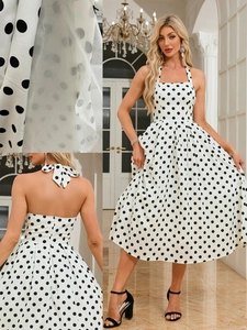 Detail of vintage polka dot dress featuring mesh fabric, halter neckline, and bow back